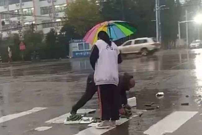 雨中为卖菜老人撑伞的姑娘，你真美！