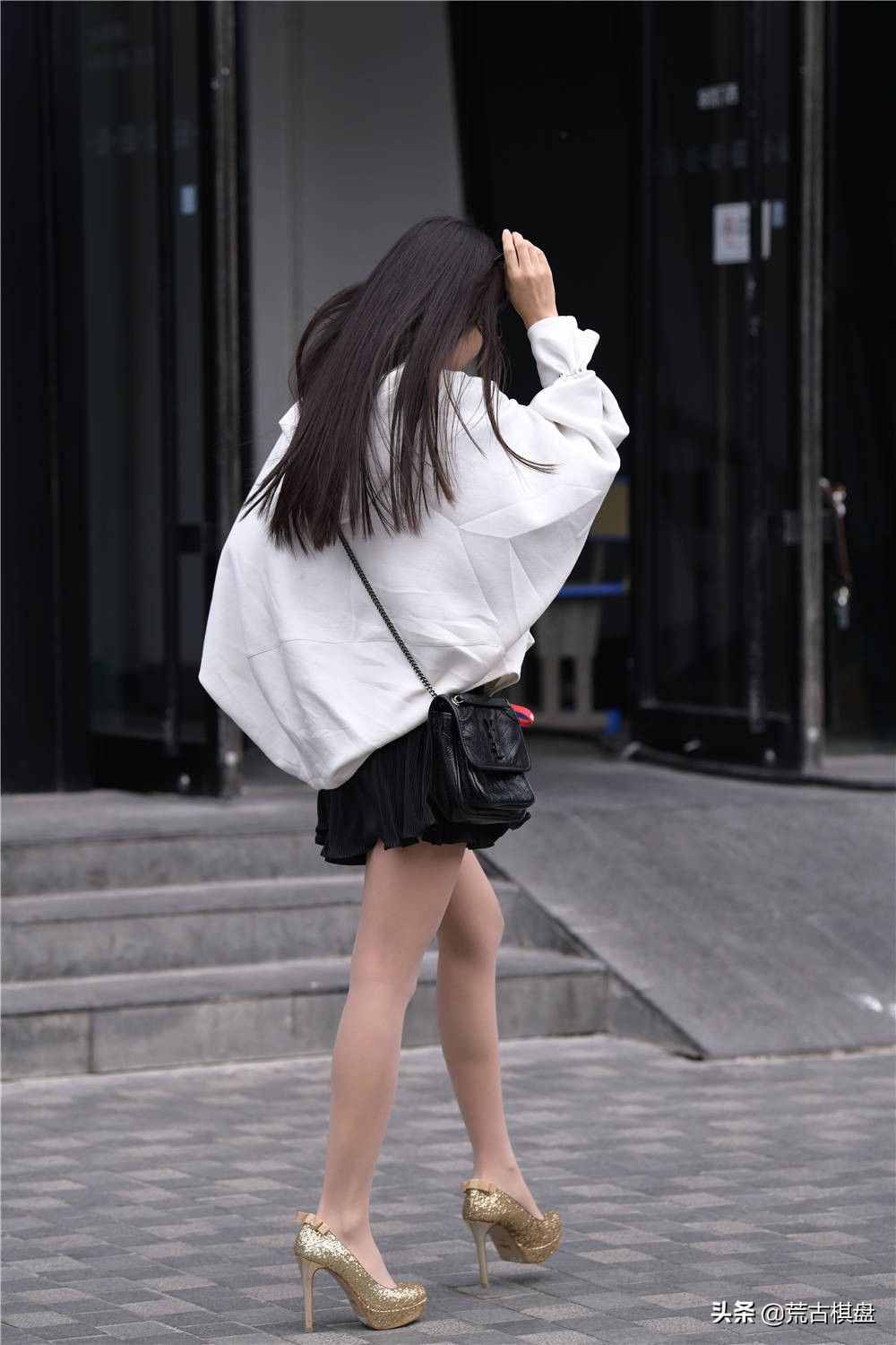 黑色短裙搭配白色宽松外套，休闲风的搭配，搭配金色的细跟鞋