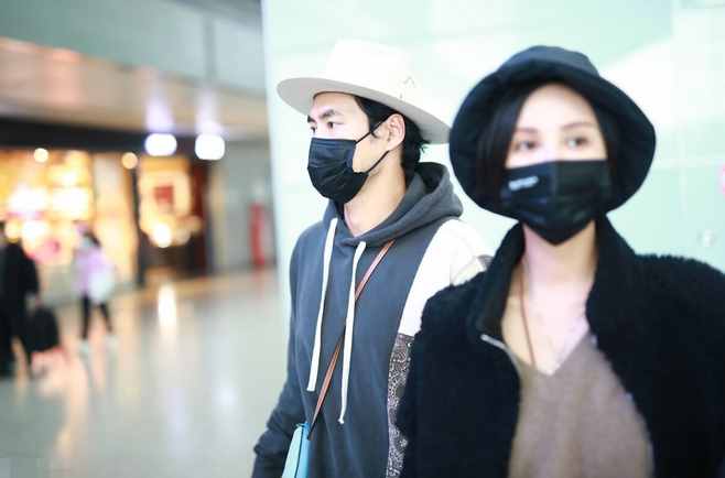 张歆艺和老公穿情侣装走机场，脖子上戴金项链，老公背女包